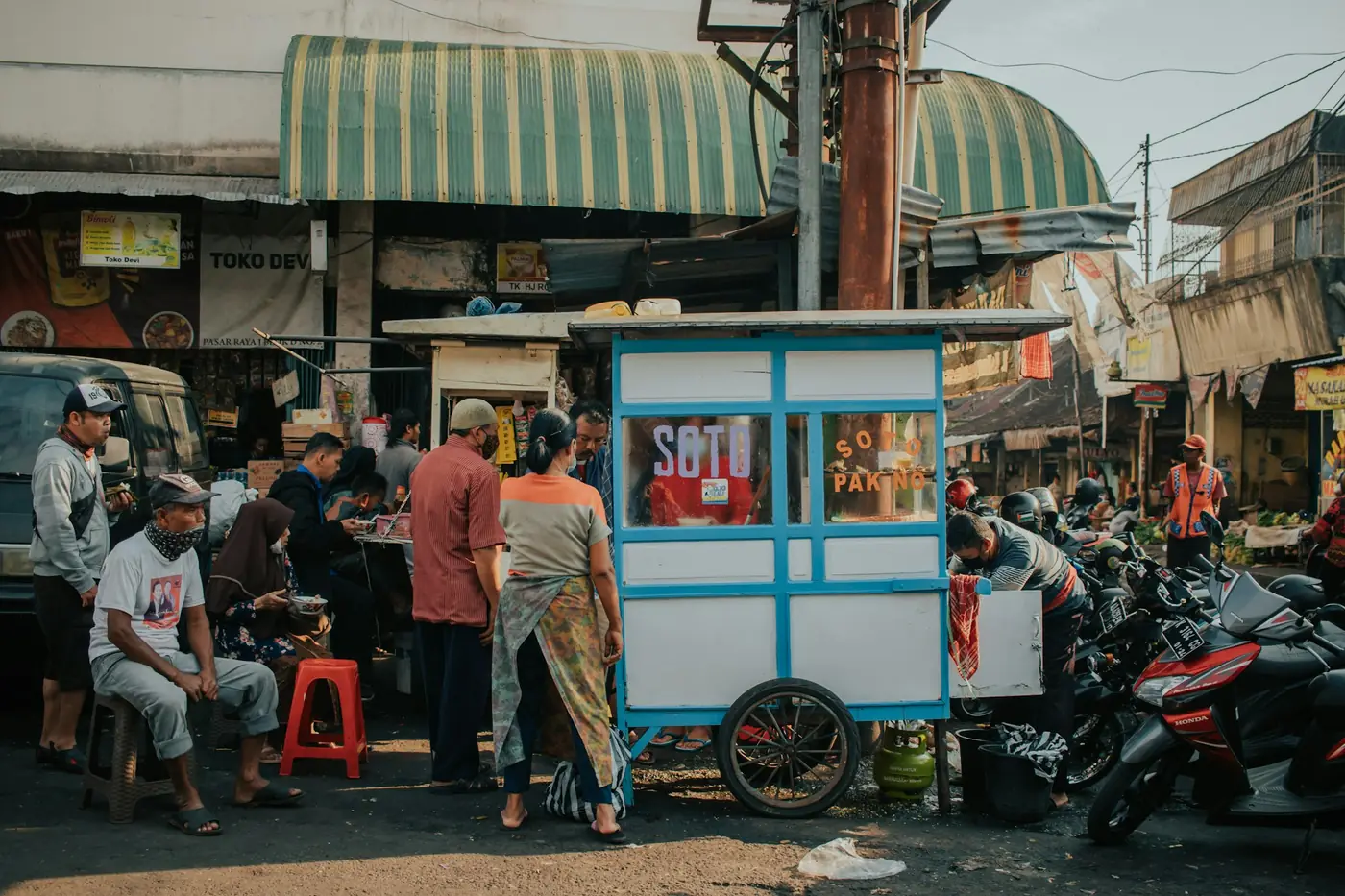 A street food cart surrounded by customers