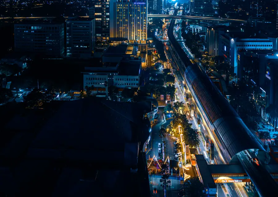A city at night seen from above, roads lit by traffic