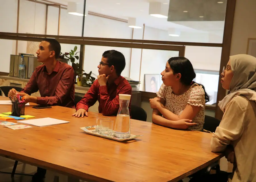 A team talking around a wooden meeting table