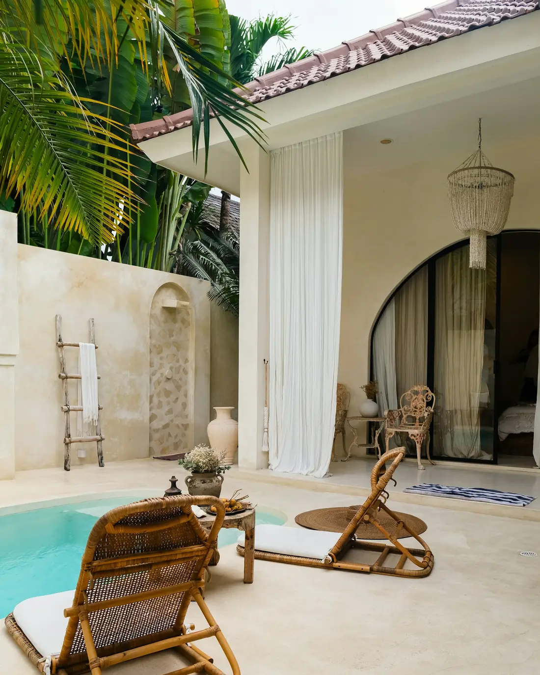 A lime-plastered suite with a plunge pool and rattan chairs
