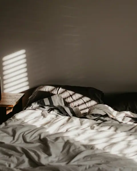Morning light on an unmade bed