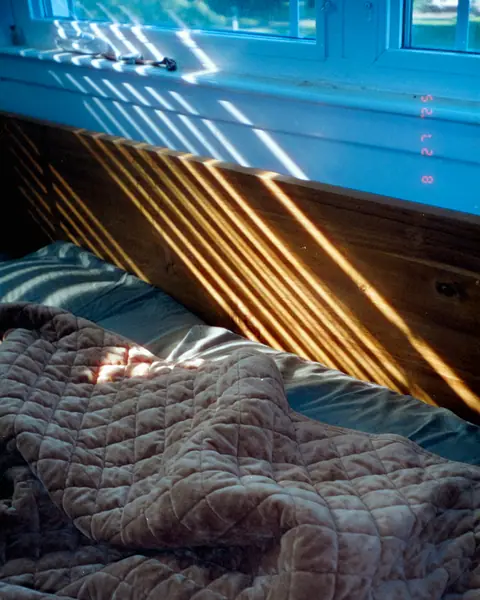 Sunlight falling across a quilted blanket