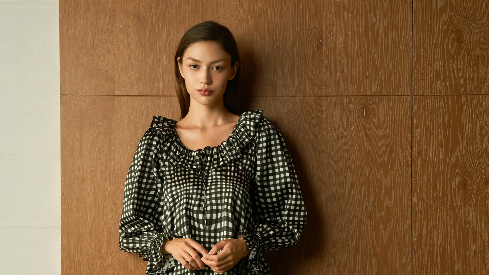 A woman in a black and white gingham pyjama set