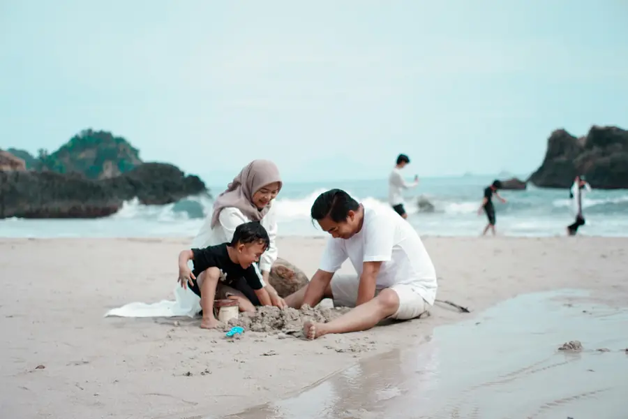 A family playing in the sand on a beach