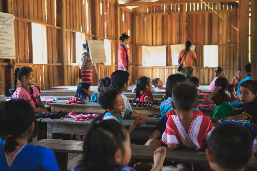 Young children in a wooden classroom with their teacher